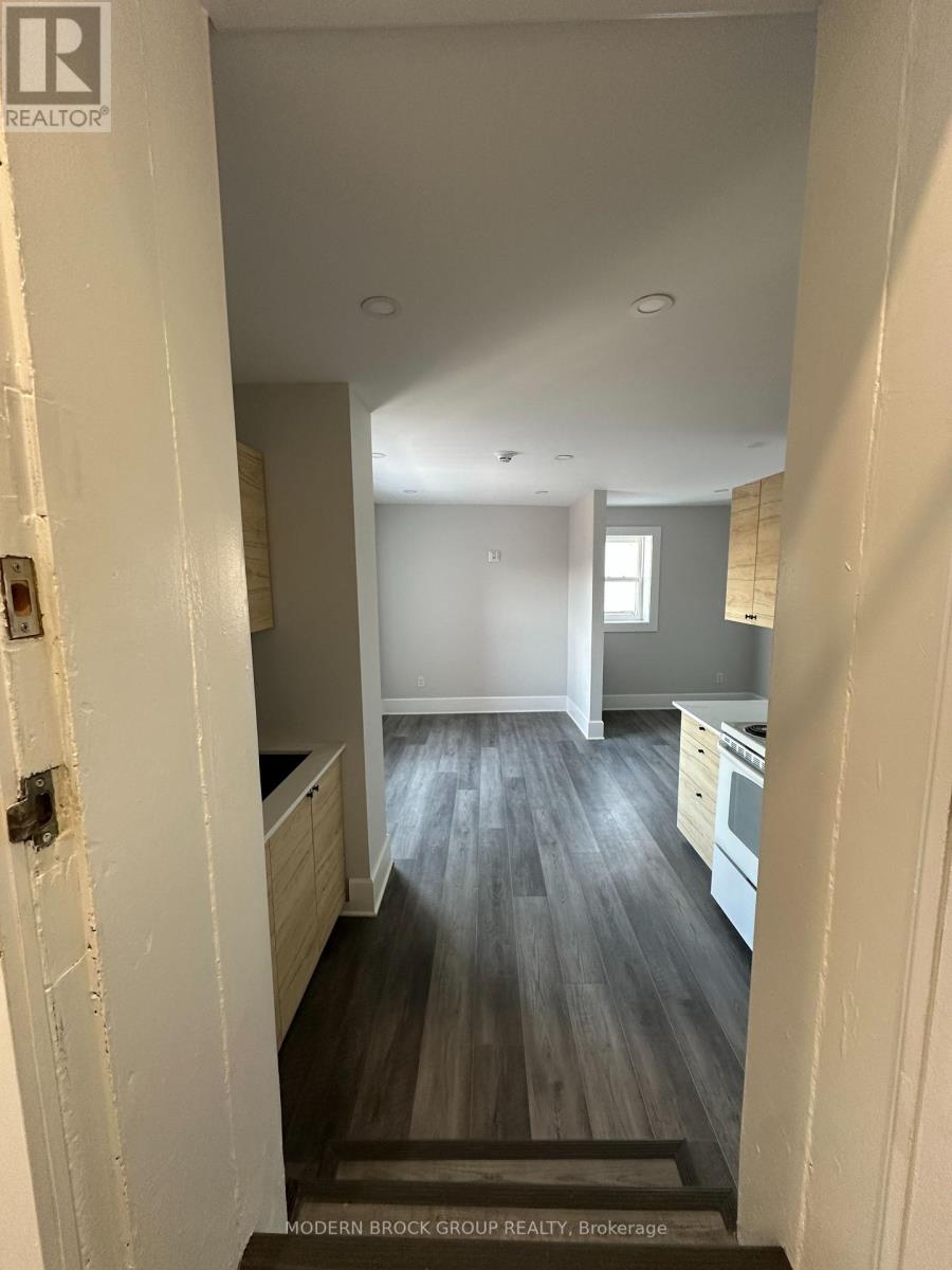 A hallway with a wooden floor and white walls.