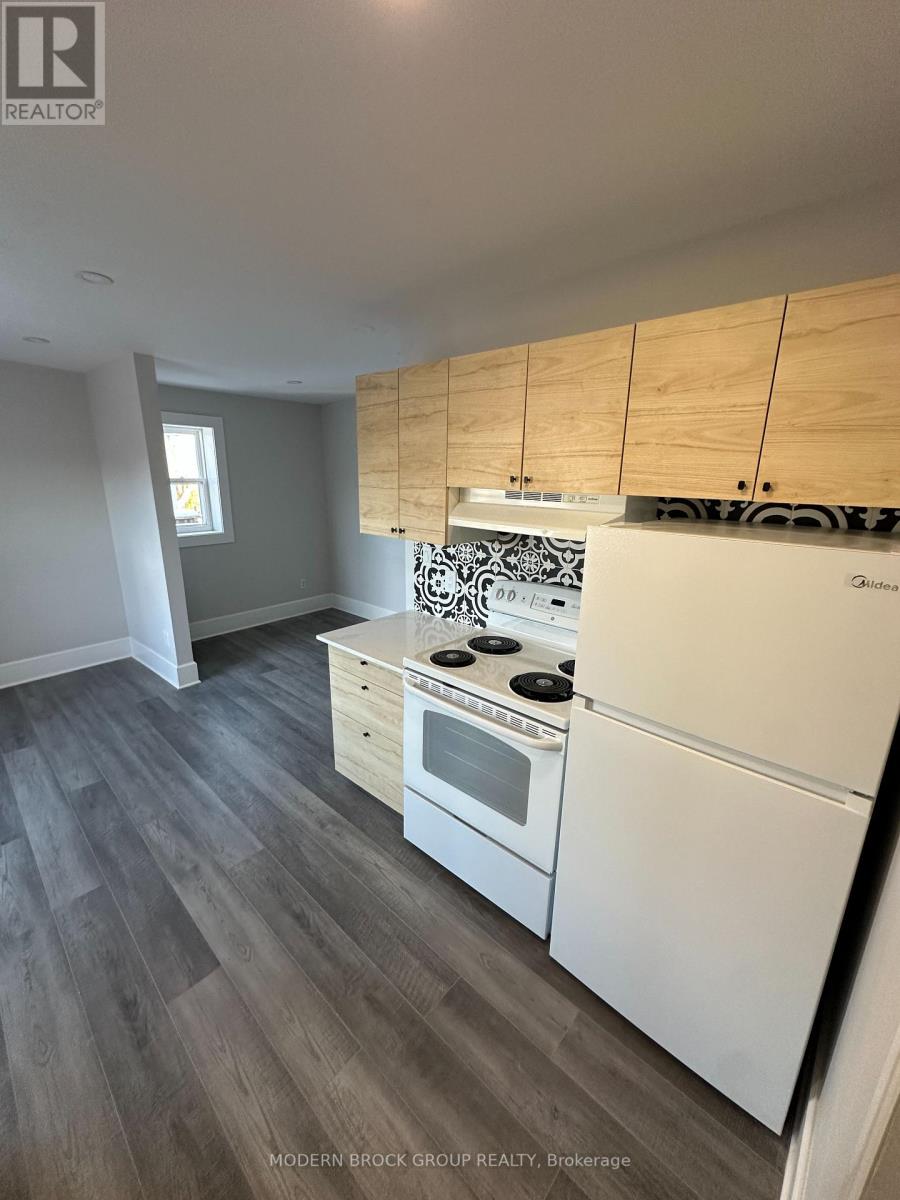 A kitchen with white appliances and wooden cabinets.