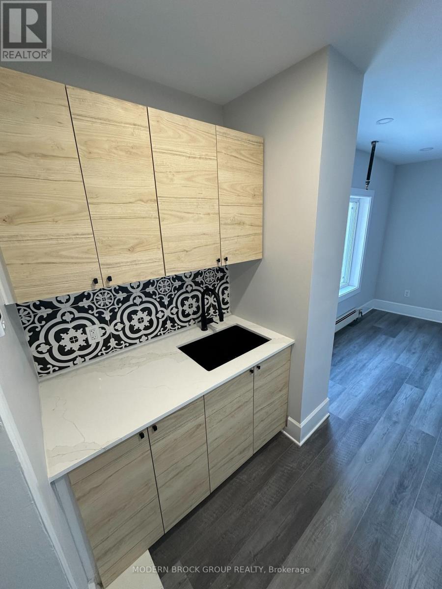 A kitchen with wooden cabinets and a black and white backsplash.
