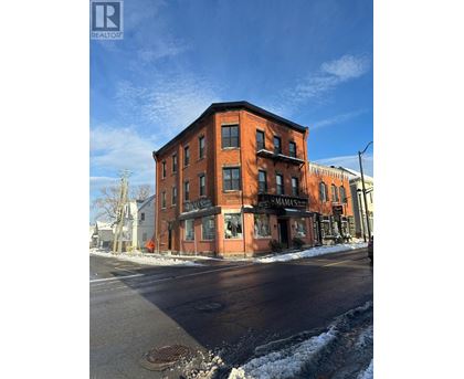 A red brick building with a black awning that says "MAMAMA" on it.