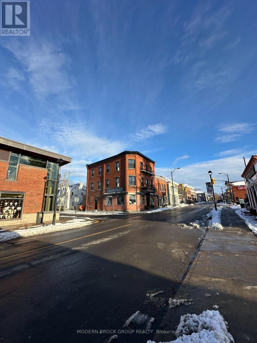 A street view of a residential area with a sign for Modern-Brock Grove Realty.