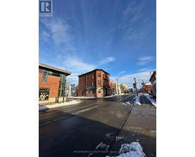 A street view of a residential area with a sign for Modern-Brock Grove Realty.