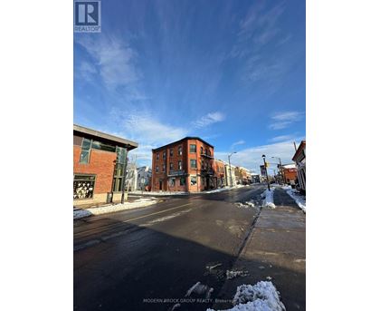 A street view of a residential area with a sign for Modern-Brock Grove Realty.