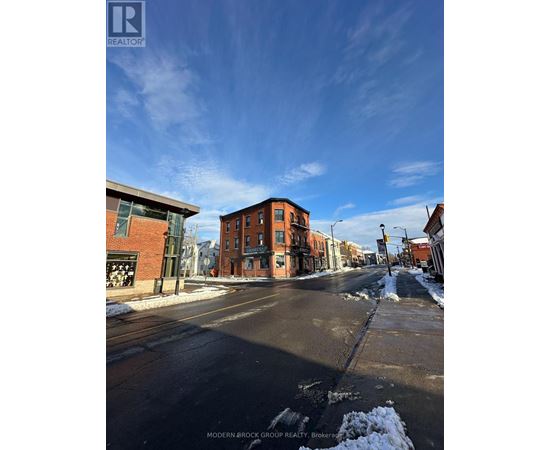 A street view of a residential area with a sign for Modern-Brock Grove Realty.