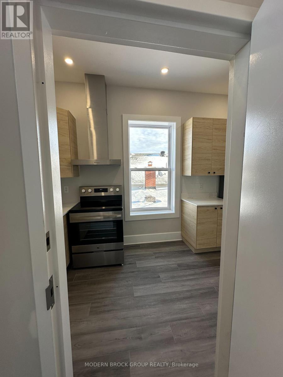 A modern kitchen with a stainless steel oven and a window.