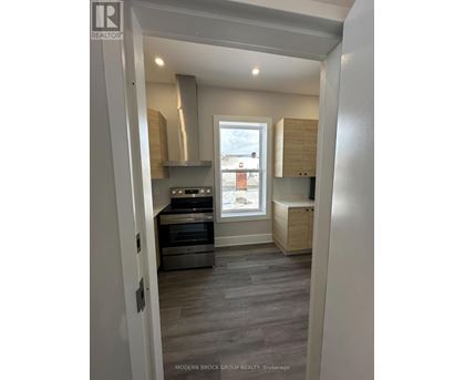 A modern kitchen with a stainless steel oven and a window.