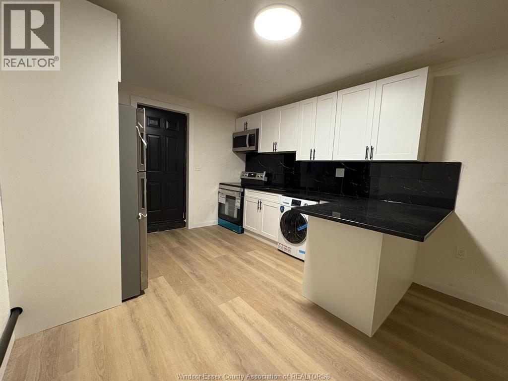 A kitchen with black countertops and white cabinets.