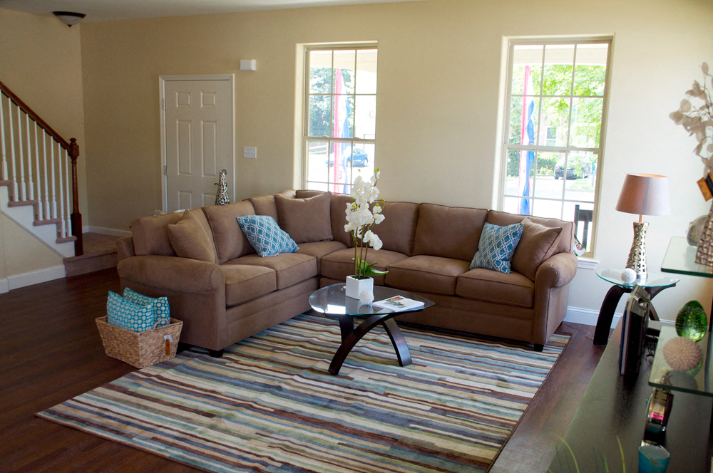 a living room with a brown couch and a rug