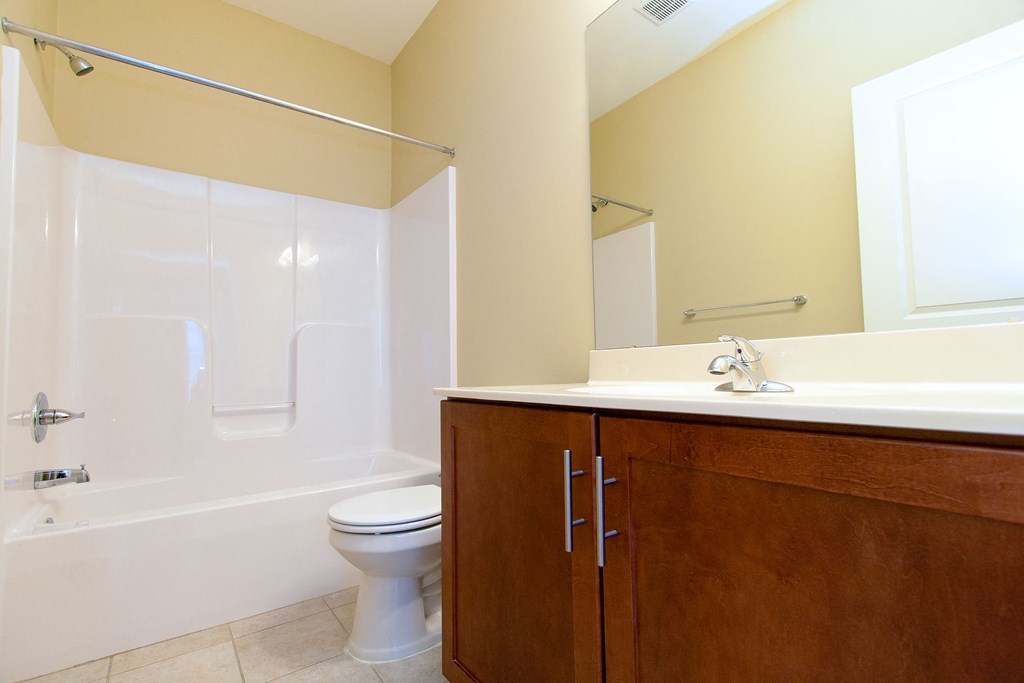 a bathroom with a toilet sink and tub and a mirror