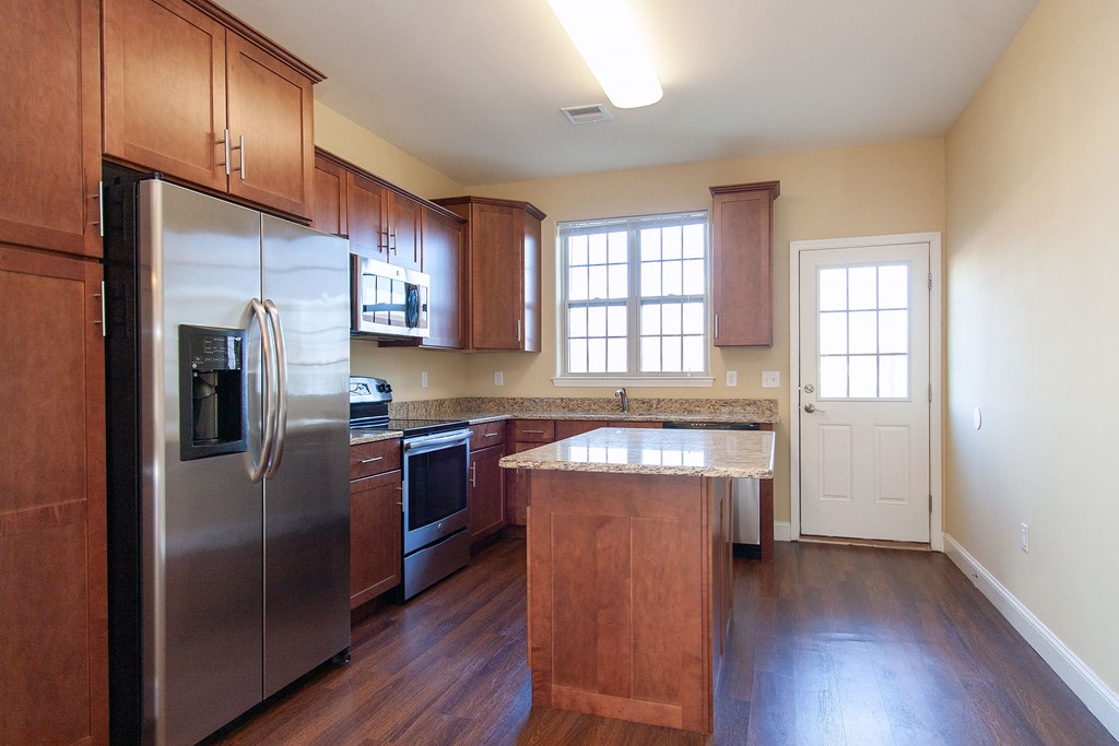 a kitchen with wooden cabinets and stainless steel appliances
