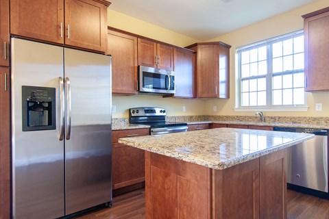 an updated kitchen with stainless steel appliances and granite counter tops