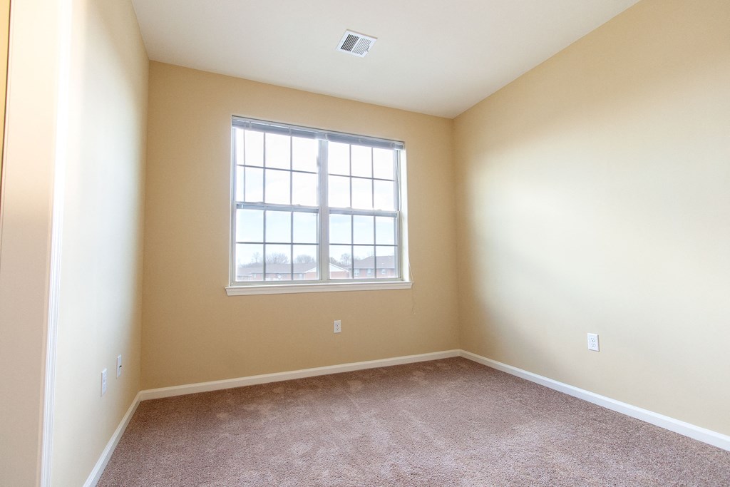 an empty room with carpet and a window