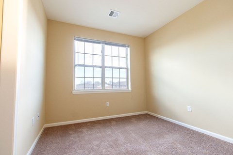 an empty room with carpet and a window