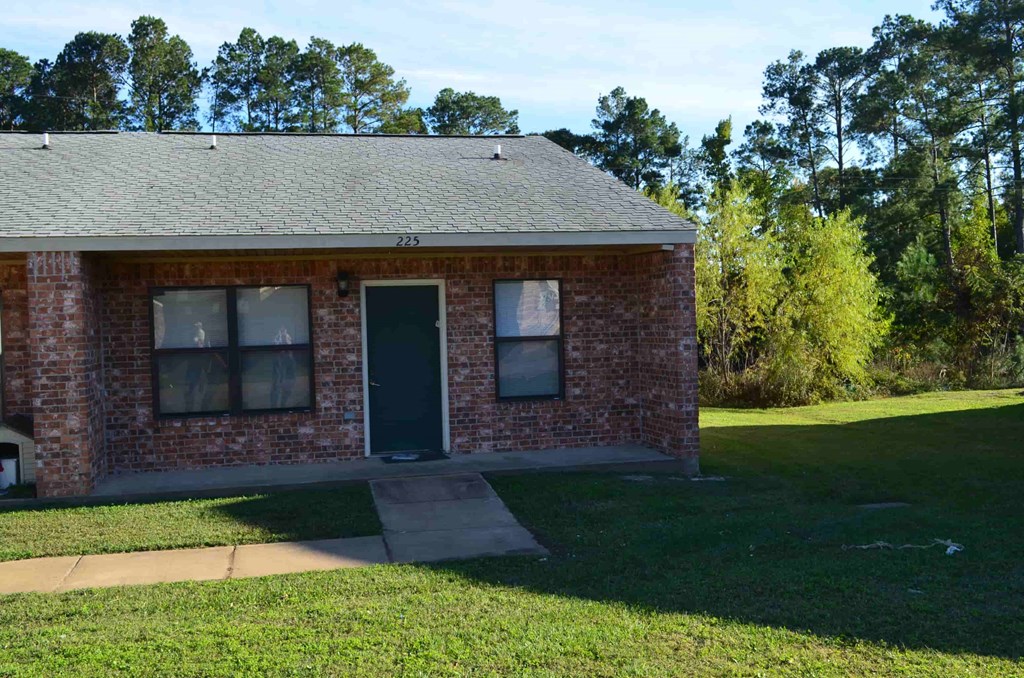 A small brick house with a black door and windows.