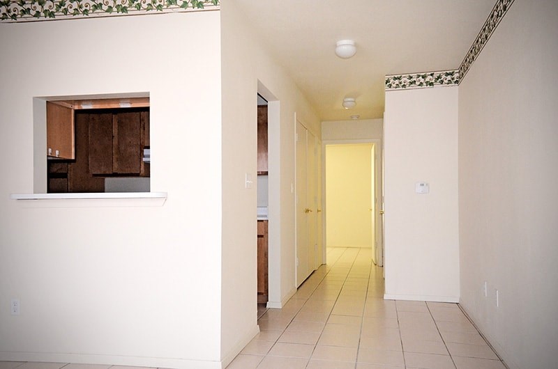 A hallway with a door at the end.