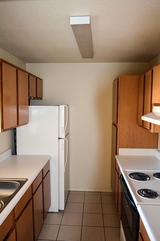 A kitchen with a white refrigerator and a white stove top oven.