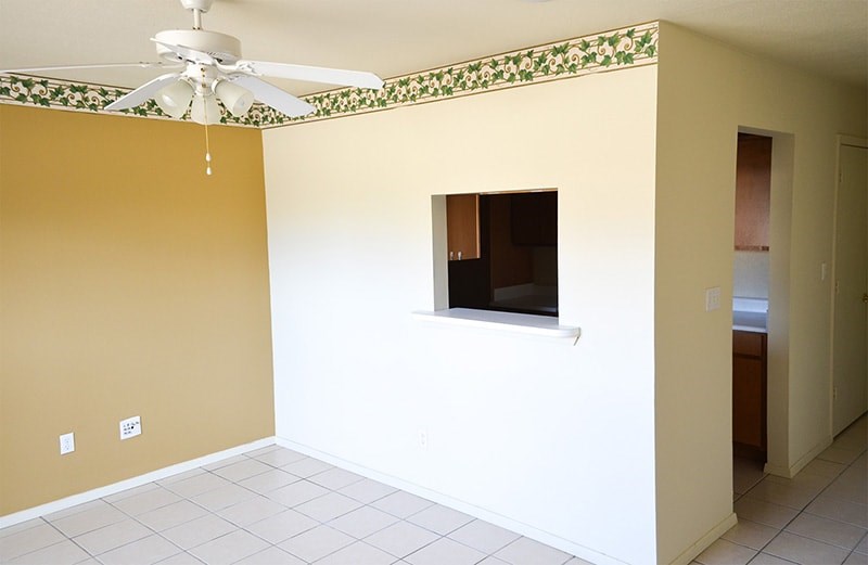 A room with a ceiling fan and a window.