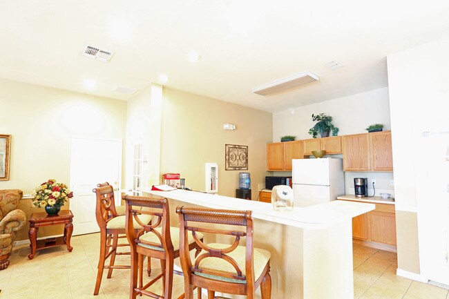 A kitchen with a dining table and chairs.