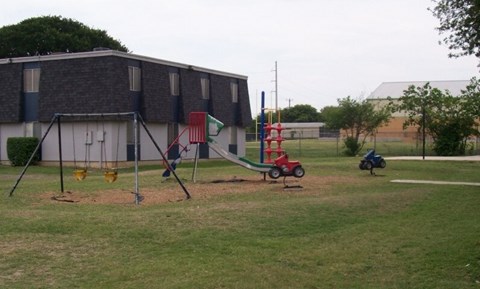 A playground with a swing set and a slide.
