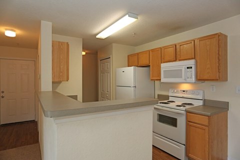 A kitchen with white appliances and wooden cabinets.