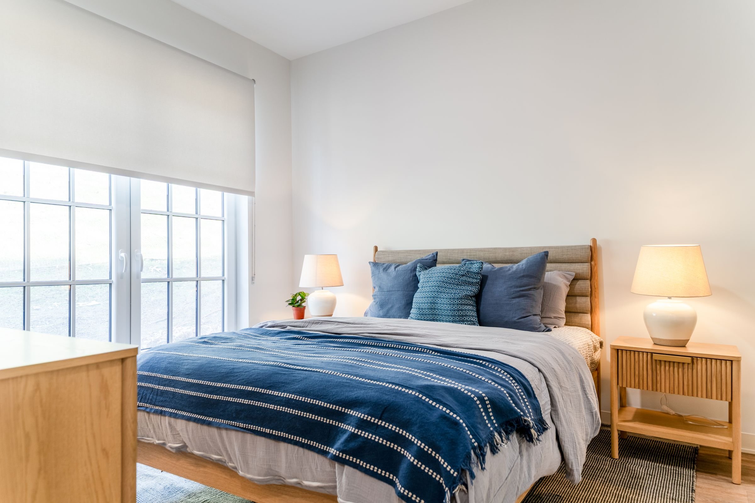 A bedroom with a large bed and a window.