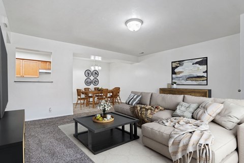 A living room with a grey coffee table and a white couch.