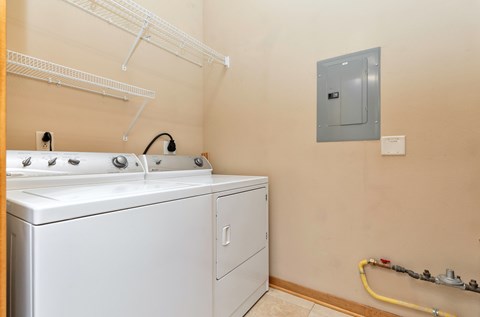 A white dishwasher and washing machine in a small laundry room.