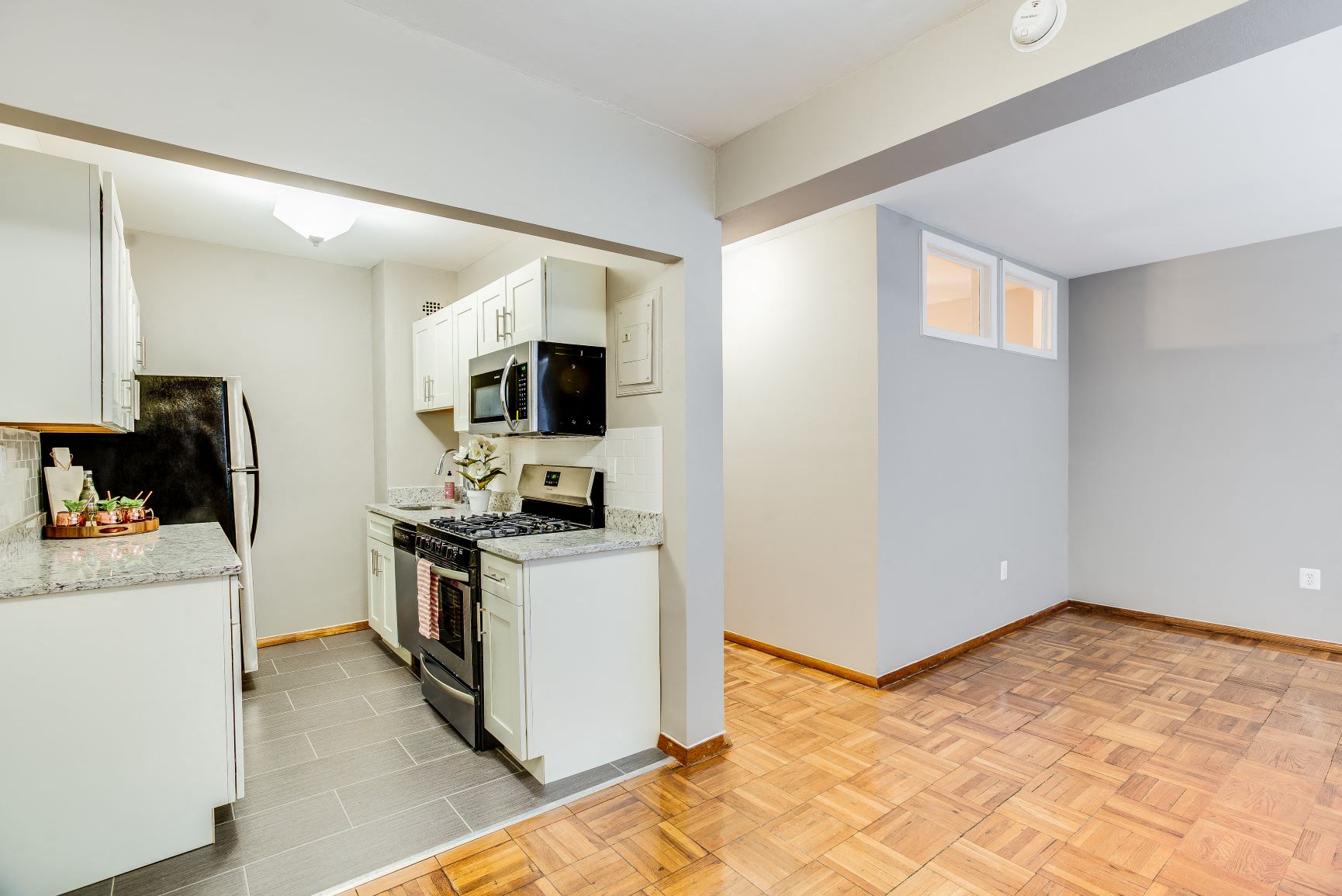 A kitchen with a refrigerator, oven, and microwave.