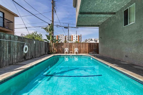 A small pool with a blue tinted water in a residential area.