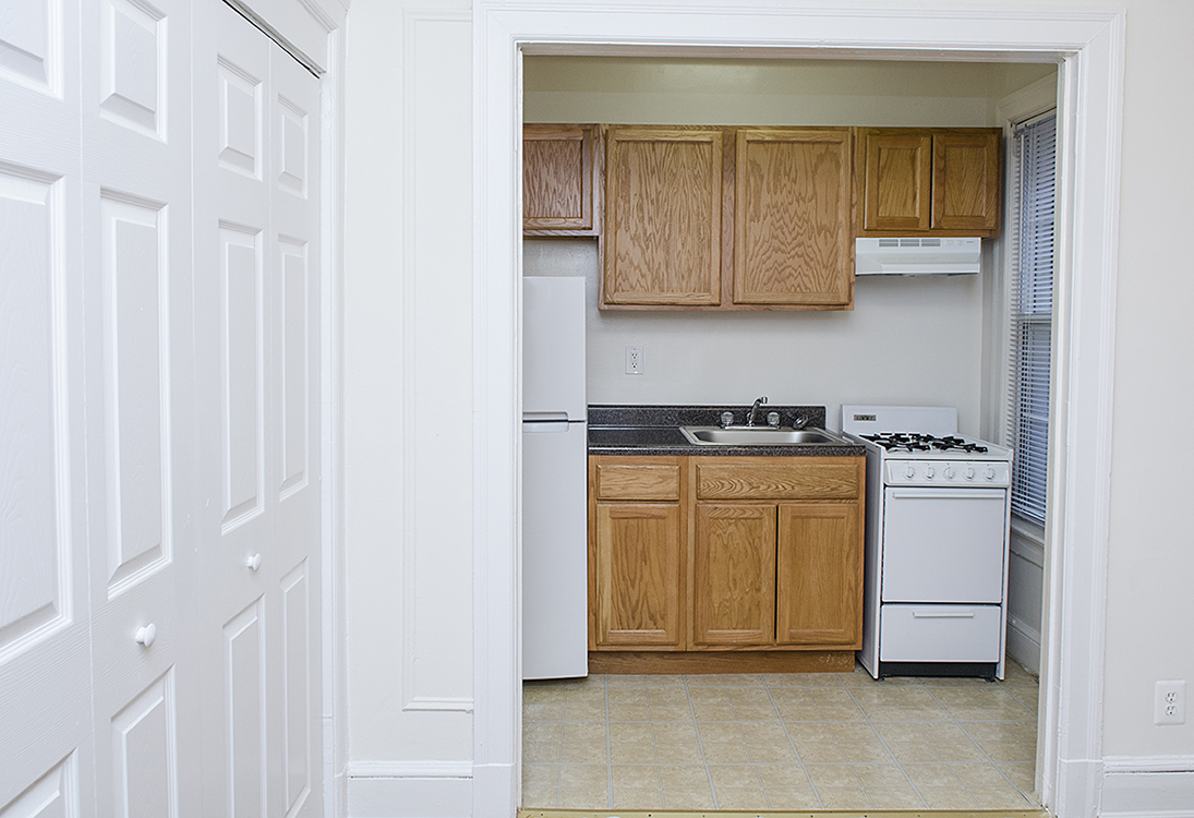 A kitchen with white appliances and wooden cabinets.