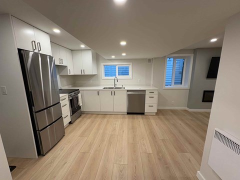 A kitchen with wooden floors and stainless steel appliances.