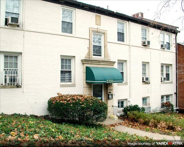 A white building with a green awning and a sign that reads 2320.