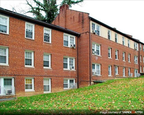A red brick building with white windows and shutters.