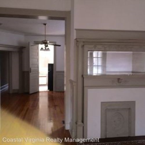 A room with a fireplace and a ceiling fan.