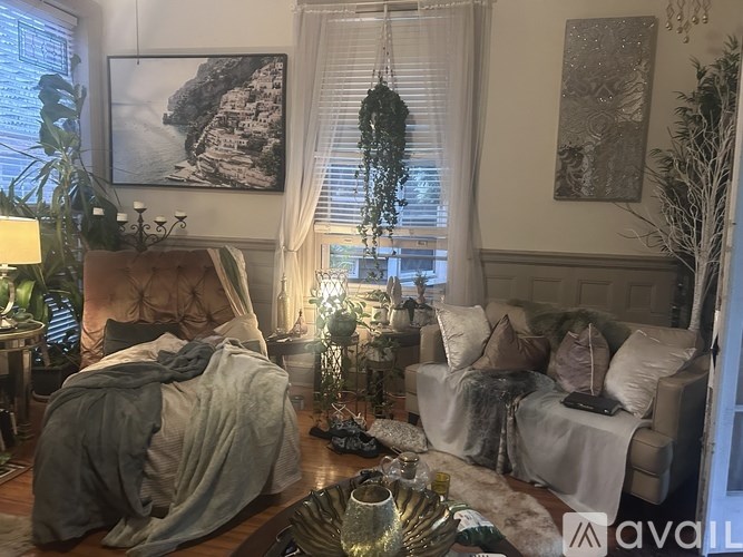 A living room with a couch, a chair, a table, and a painting on the wall.