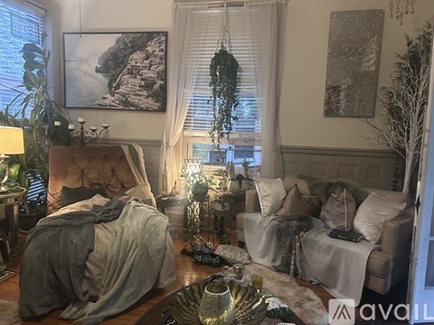 A living room with a couch, a chair, a table, and a painting on the wall.