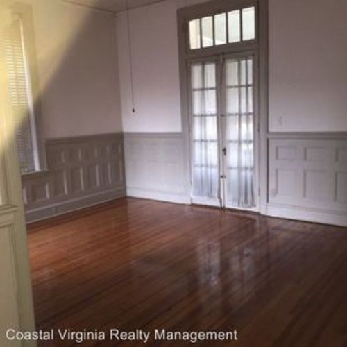 A room with wooden floors and a large window.