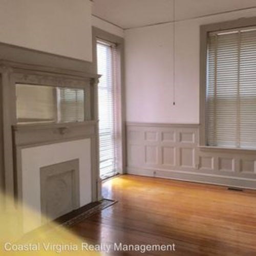 A room with a fireplace and wooden floors.