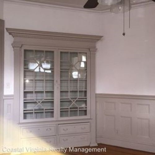 A window with a white frame and a ceiling fan in a room.