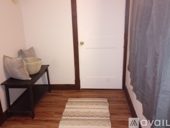 A hallway with a bench and a door.