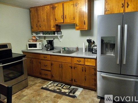 A kitchen with wooden cabinets and a refrigerator.