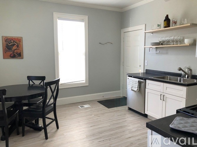 A kitchen with a table and chairs in front of a window.
