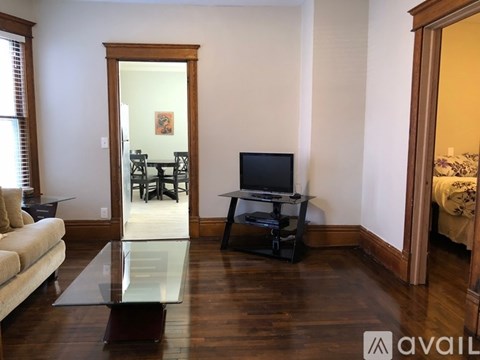 A living room with a glass table and a television.