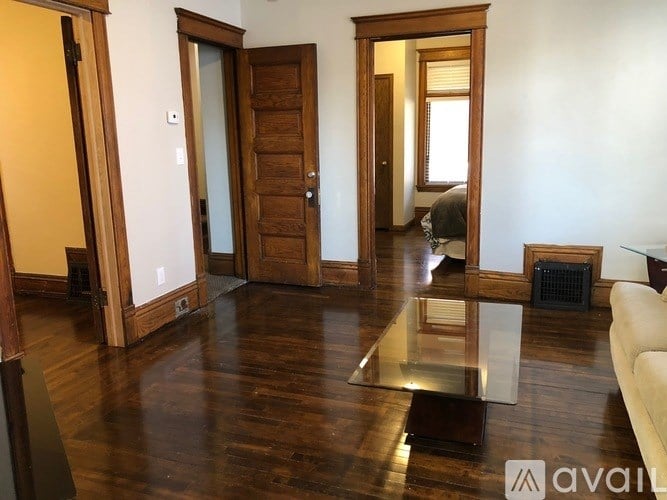 A living room with a glass coffee table and a white couch.