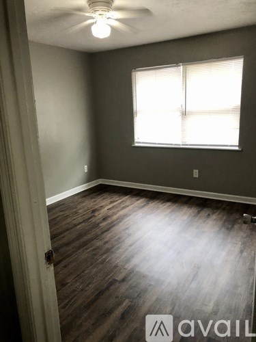 A room with a window and wooden flooring.