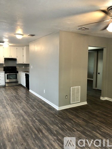 A kitchen with wood flooring and a stove top oven.