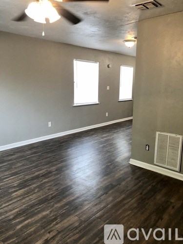 A room with wooden floors and a ceiling fan.
