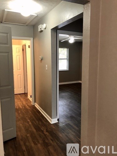 A hallway with a door on the left and a window on the right.