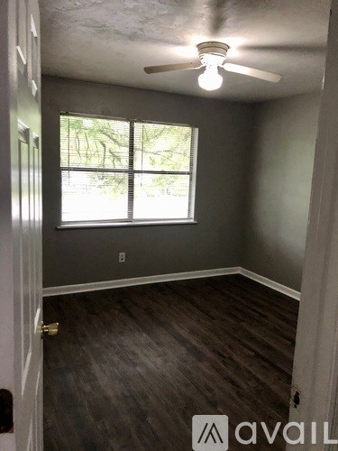 A room with a ceiling fan and a window.