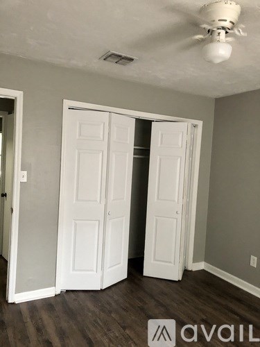 A room with a white ceiling fan and two white doors.